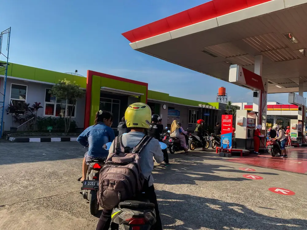 Motorcyclists waiting in line at a fuel station before starting a long road trip in Leh