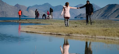 Couple walking with reflection at Pangong Lake Ladakh