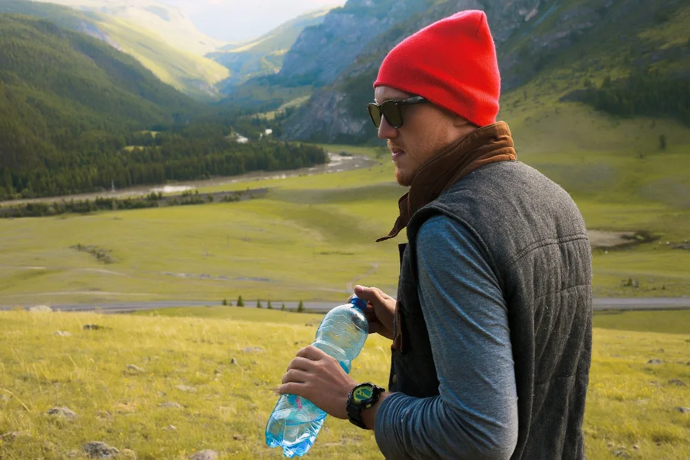 Traveler drinking water while trekking in the scenic valleys of Ladakh