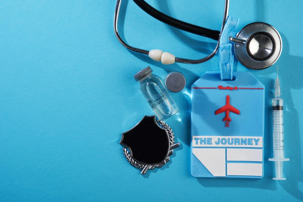 Travel health items including a stethoscope, syringe, vaccine vial, and travel tag with airplane symbol.