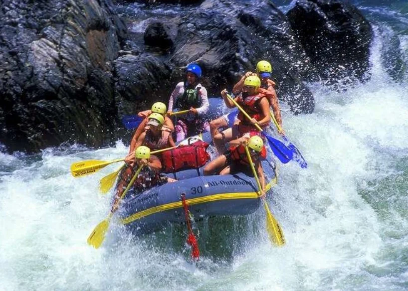 People enjoying an exciting white water rafting adventure on a fast-flowing river in Sikkim.
