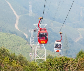 Cable cars gliding over lush green hills with panoramic mountain views in Sikkim.