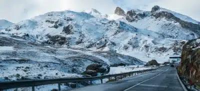 Snow-covered mountains and a highway winding through Ladakh.