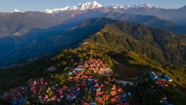 Aerial view of a scenic Sikkim village with the Himalayan mountains in the background.