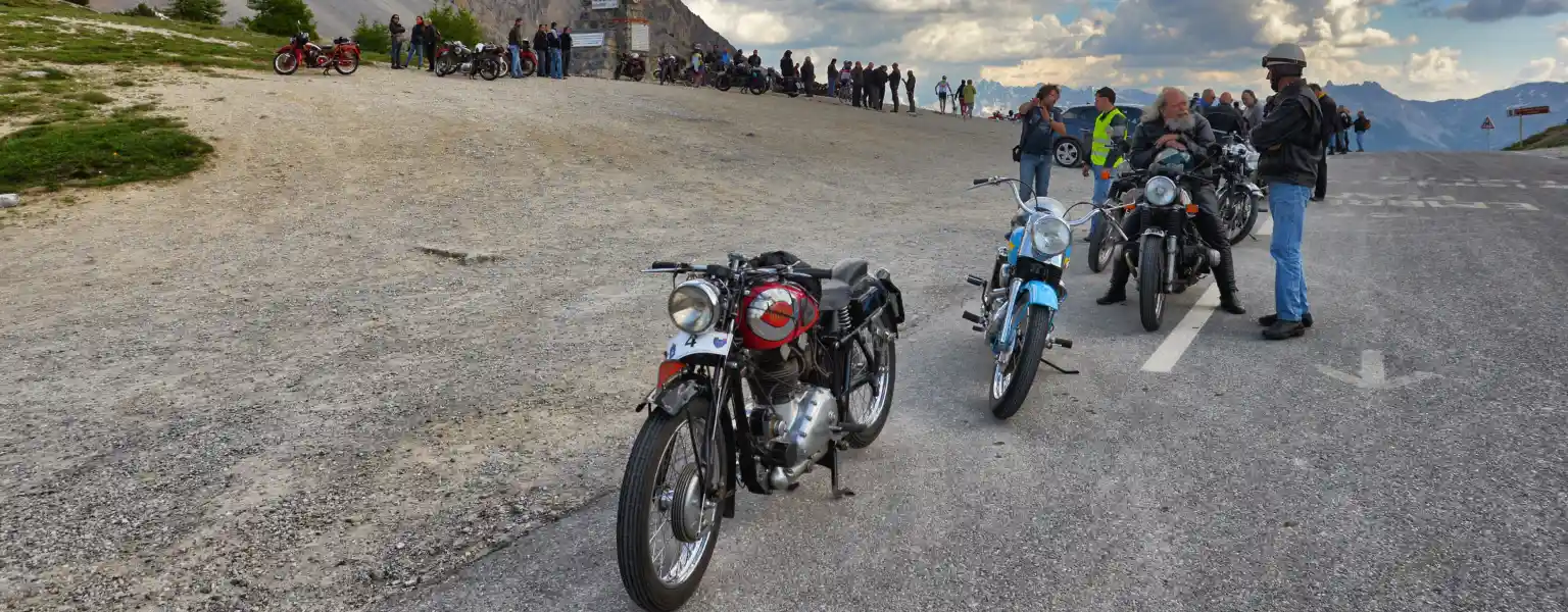 Motorcycles parked beside a river in Ladakh with mountains in the background.